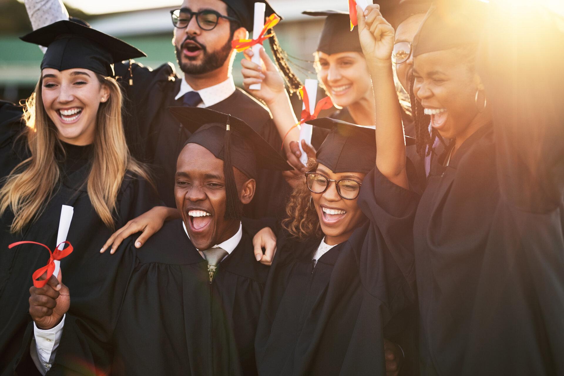 cheerful university students on graduation day.