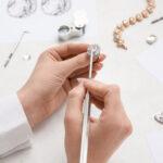 Jeweler making ring on white table, closeup